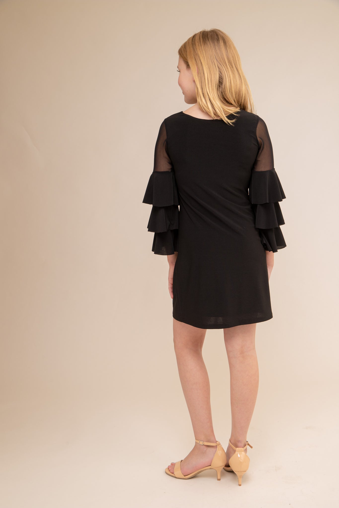 This is an all over stretch, black tiered sleeve dress with mesh detailing on the sleeve. Hits above the knee for a beautiful and chic silhouette.