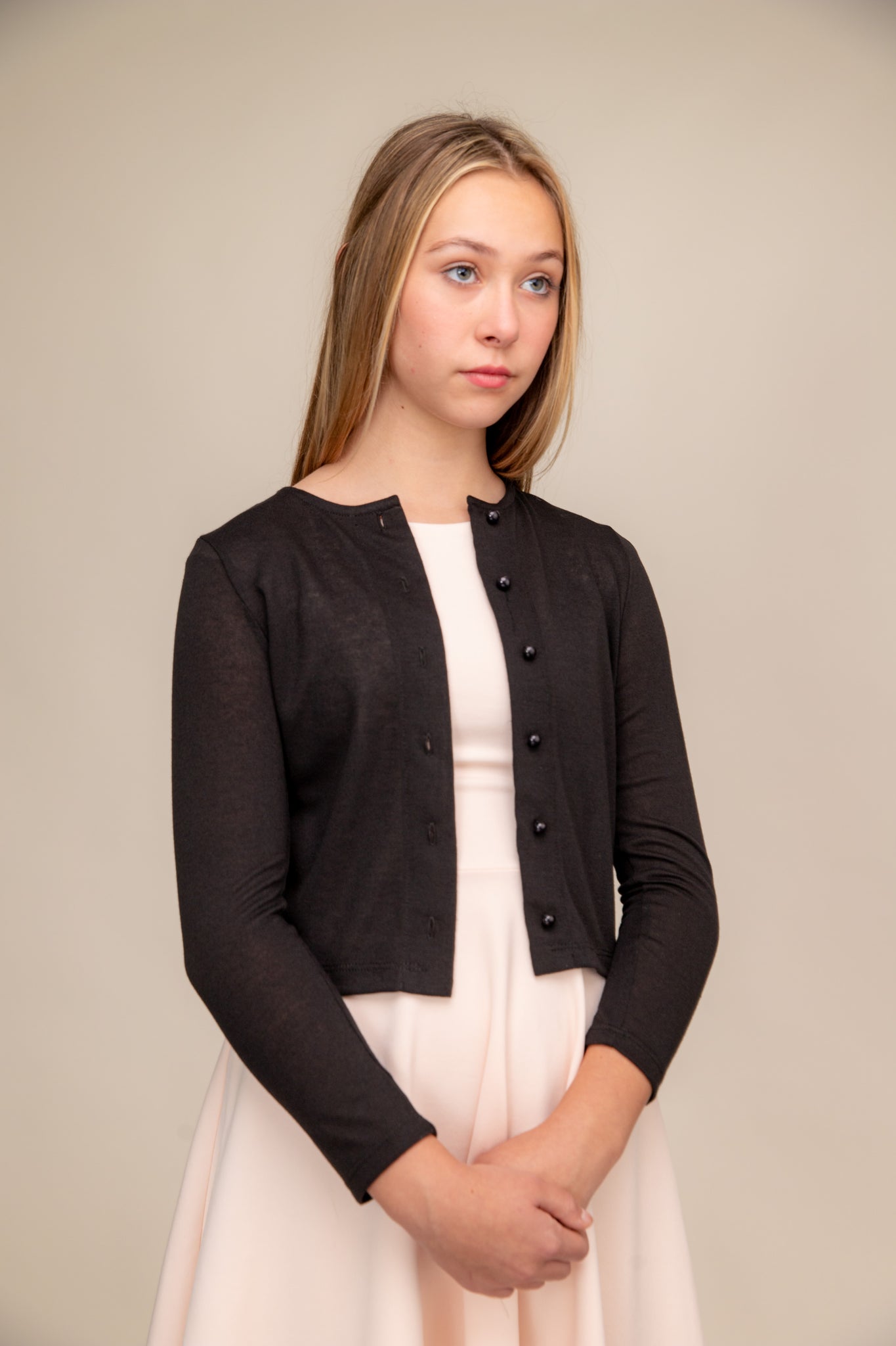 This is a button up cardigan with plastic buttons, scoop neck detailing, three quarter inch sleeve length and all over stretch fabric in black.