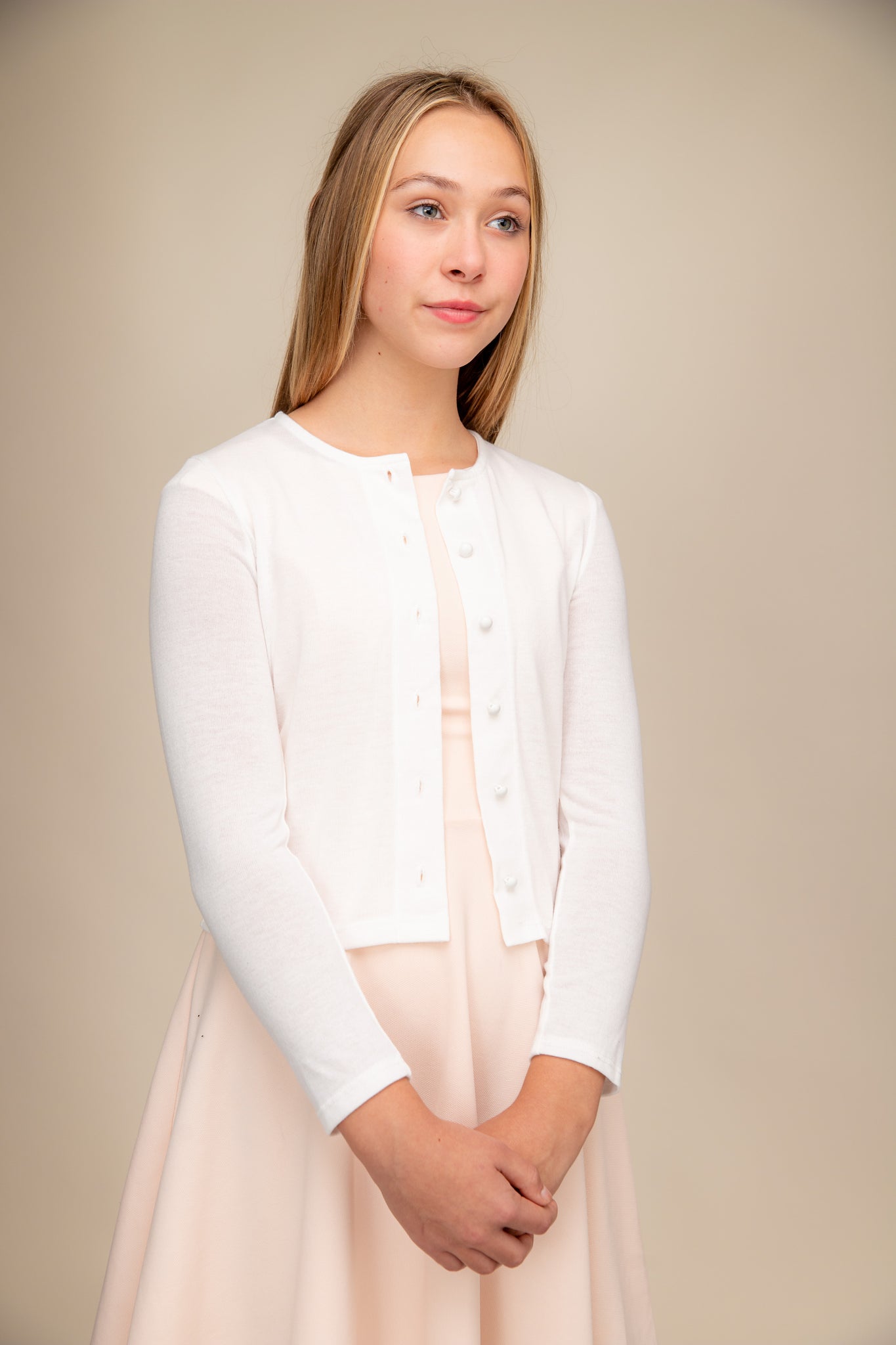 This is a button up cardigan with plastic buttons, scoop neck detailing, three quarter inch sleeve length and all over stretch fabric in ivory.