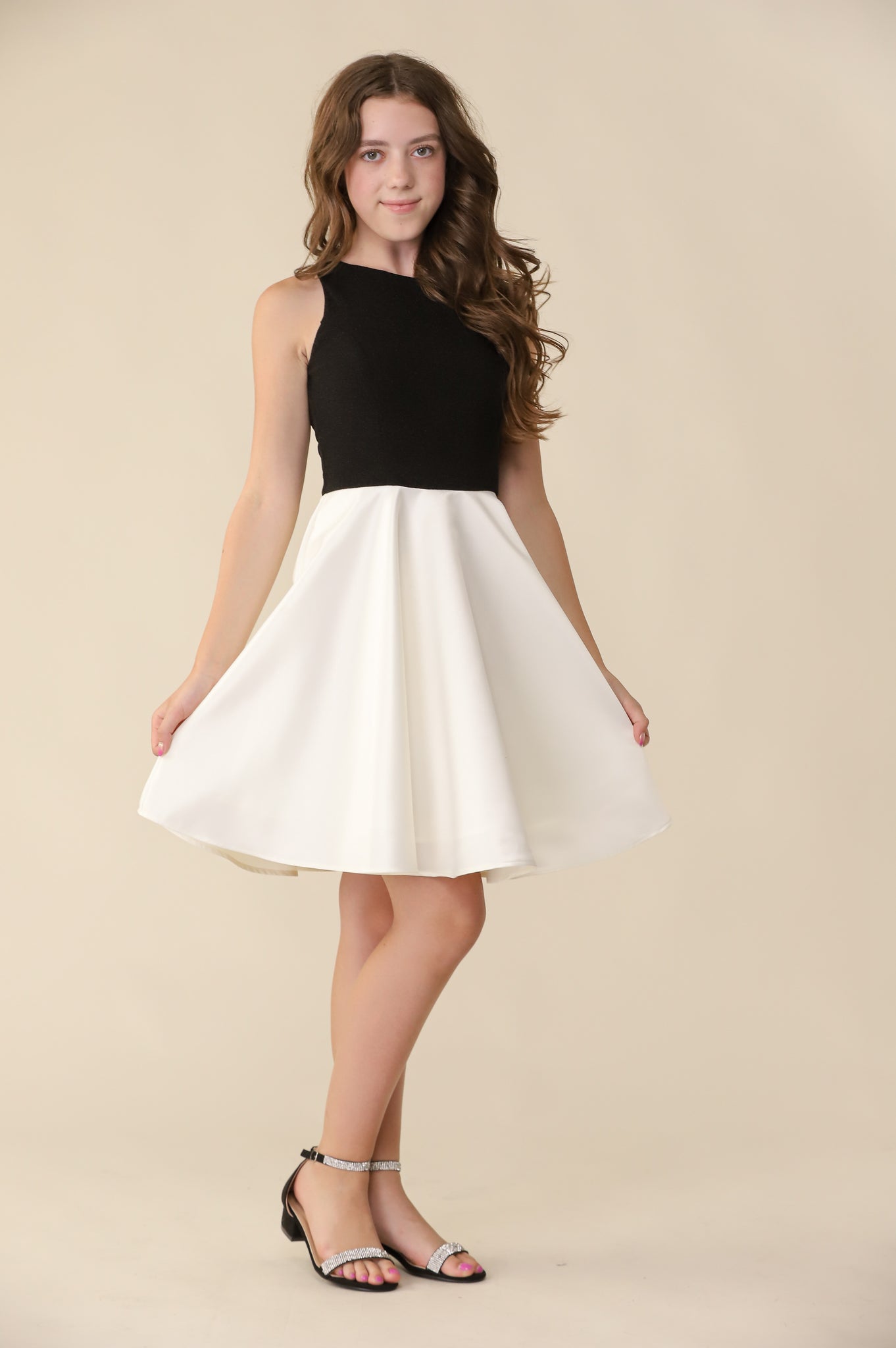 Brown haired girl in a glitter bodice dress with black circle skirt with black kitten heel.