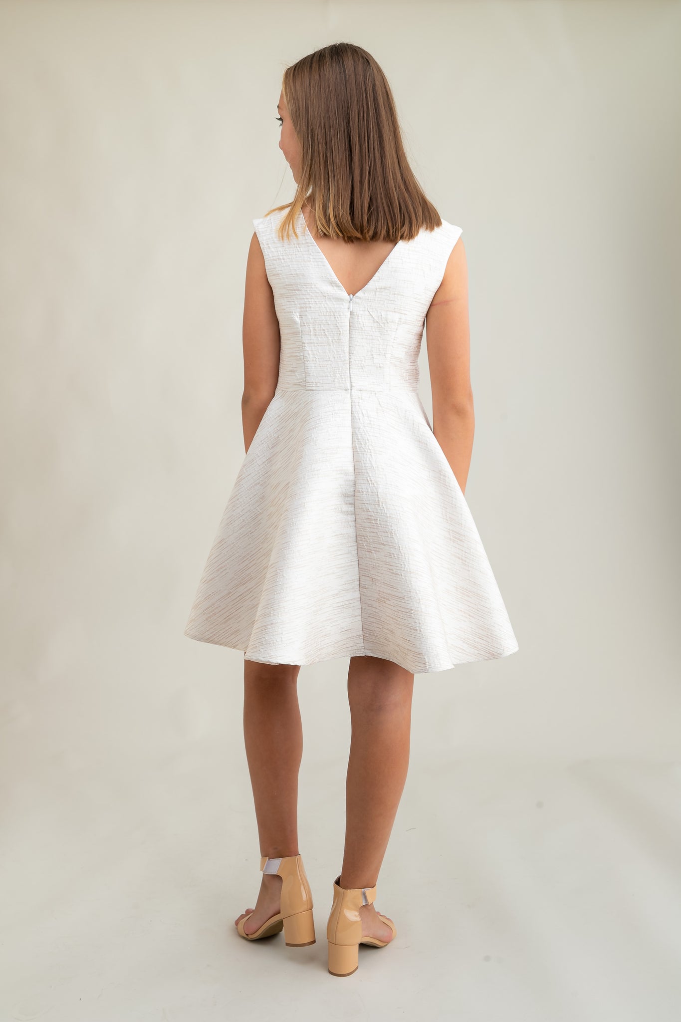This is an all over jacquard, cap sleeve dress in ivory with non-stretch material, zipper back, and longer length detailing. This dress is perfect for any religious event like bat mitzvah, cotillion or church service. 