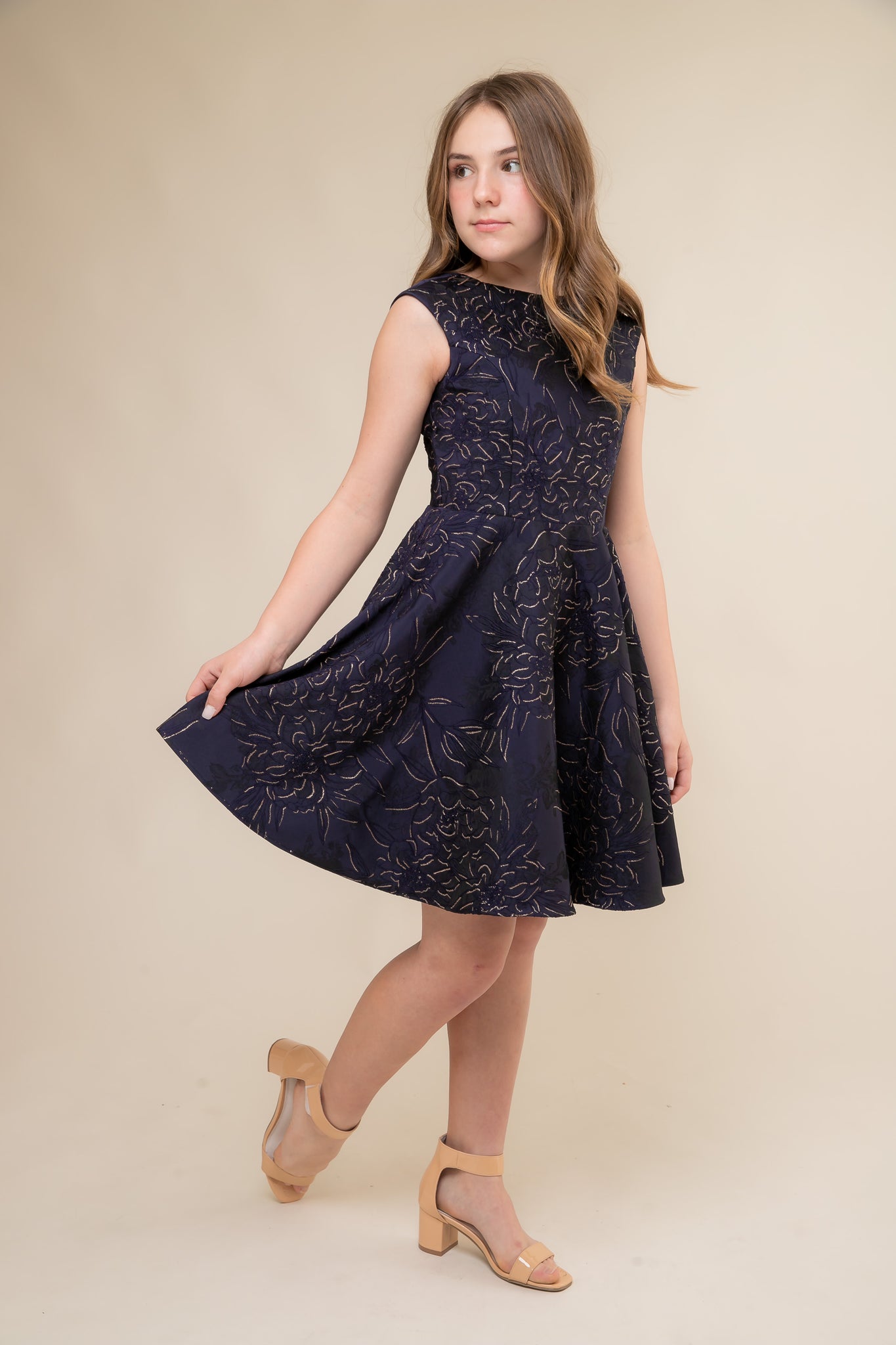 This is an all over jacquard, cap sleeve dress in navy floral with non-stretch material, zipper back, and longer length detailing. This dress is perfect for any religious event like bat mitzvah, cotillion or church service.