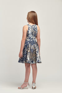 Young girl in navy and gold floral racerback style dress back view.