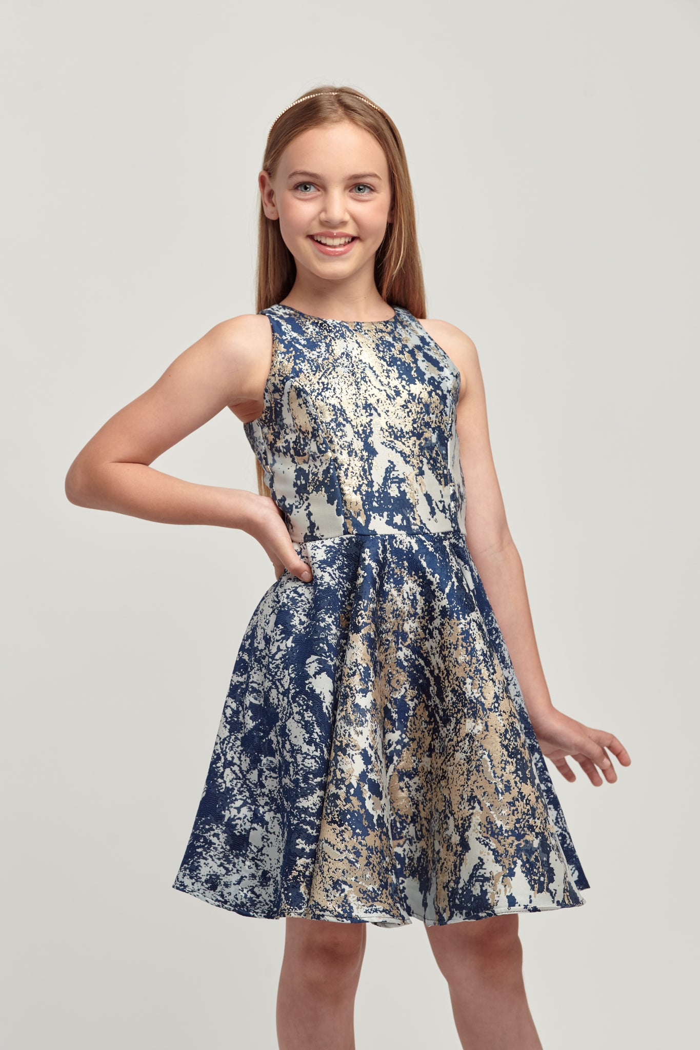 Young girl in navy and gold floral racerback style dress.