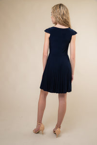 Cap sleeve pleated skirt in navy with all over stretch fabric, cap sleeve detailing for shoulder coverage and hits above the knee.