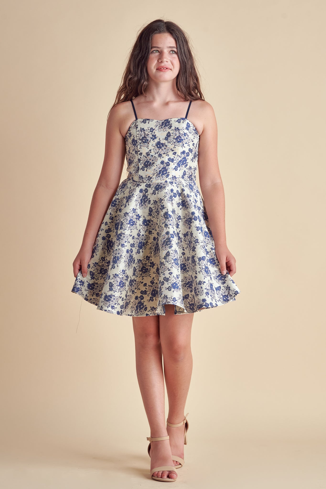 Young girl in a blue floral fit and flare dress.