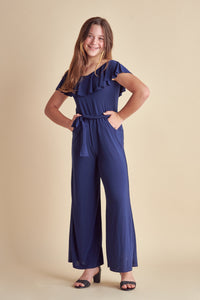 This is the all over stretch jumpsuit in navy with flutter off the shoulder sleeve and knotted belt. Features two real pockets and wide leg detailing.