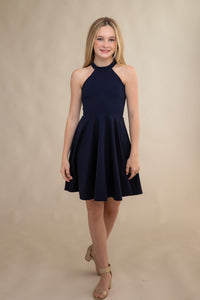 Halter dress in navy blue features a full circle twirl skirt, open hole detailing in back and high waist line for a chic silhouette.