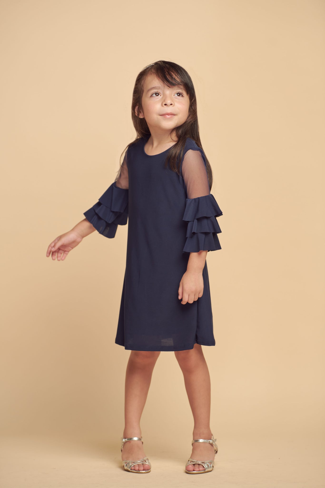 This is an all over stretch, navy tiered sleeve dress with mesh detailing on the sleeve. Hits above the knee for a beautiful and chic silhouette.