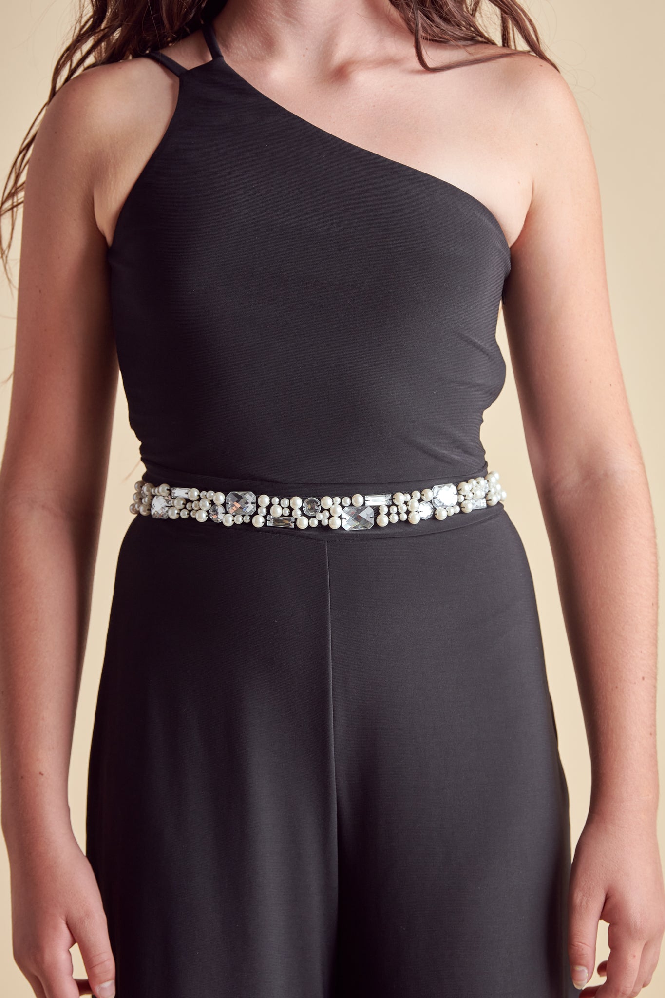 Girl in a black elasticated belt with pearl and gems.