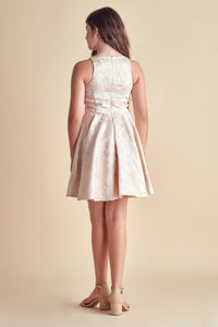Young girl in light pink floral racerback dress.