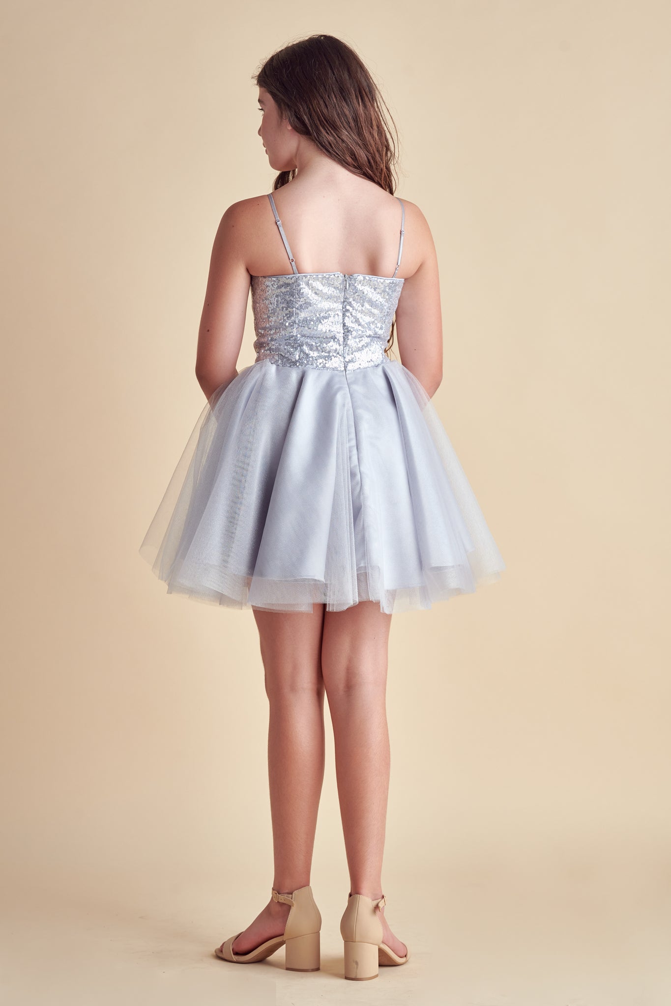 This is sequin bodice dress in silver with full tulle skirt with adjustable straps. Hits above the knee with zipper back detailing. This perfect bat mitzvah dress or party outfit for any girl.