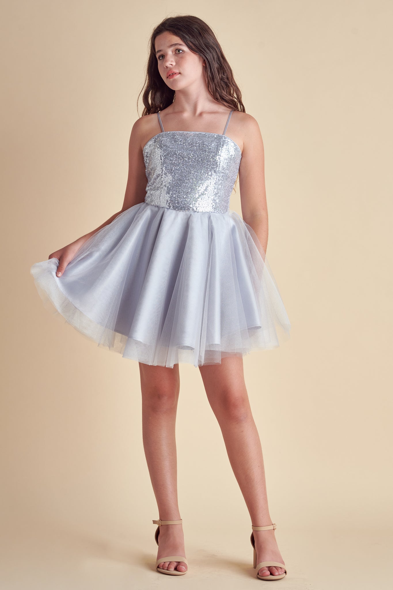 This is sequin bodice dress in silver with full tulle skirt with adjustable straps. Hits above the knee with zipper back detailing. This perfect bat mitzvah dress or party outfit for any girl.