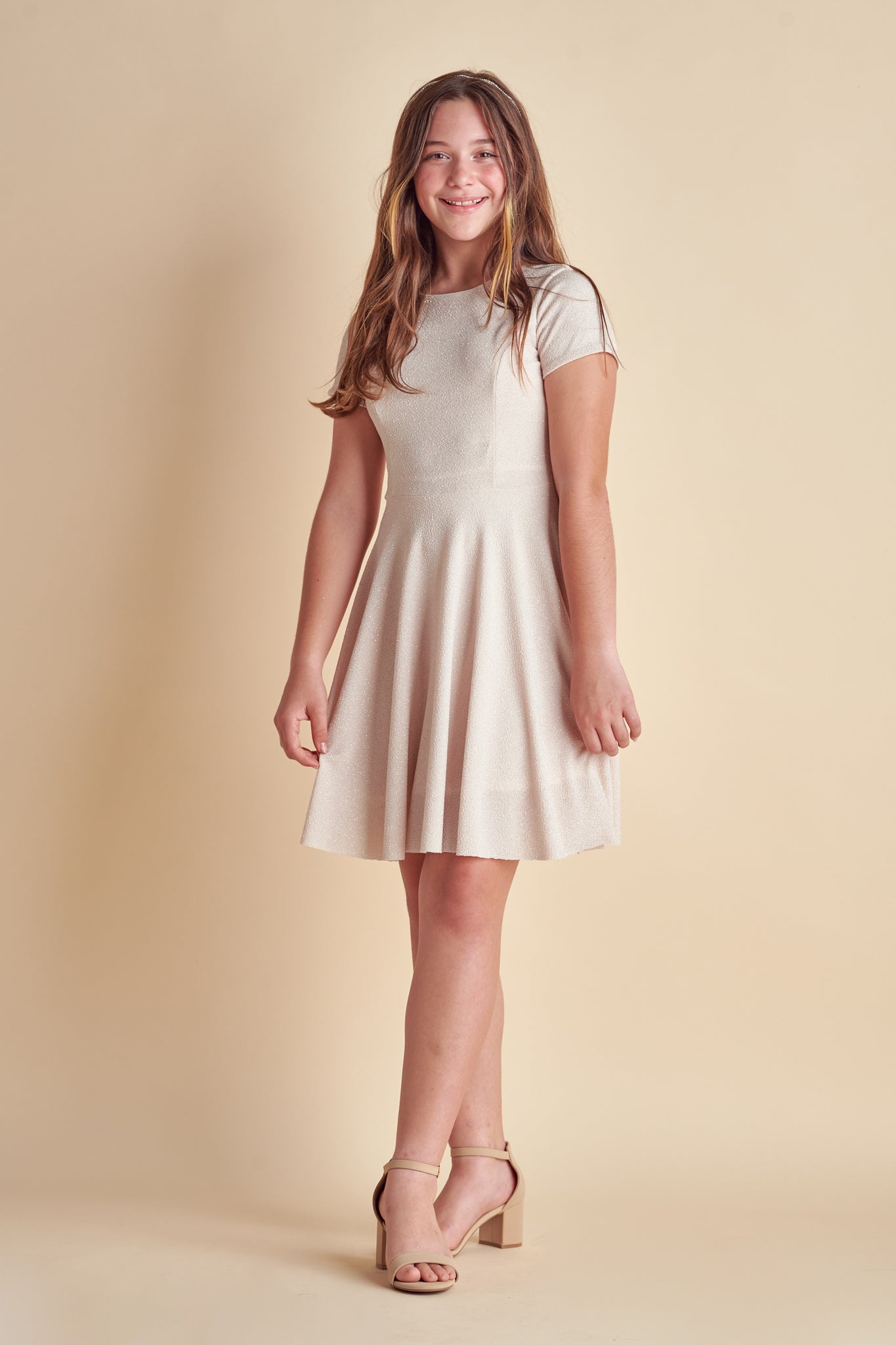 This is an all over champagne stretch glitter dress made with soft lining. It's non-scratch fabric is a perfect dress that hits right above the knee and has a lower v-back detailing.