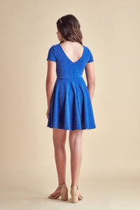 This is an all over cobalt stretch glitter dress made with soft lining. It's non-scratch fabric is a perfect dress that hits right above the knee and has a lower v-back detailing.