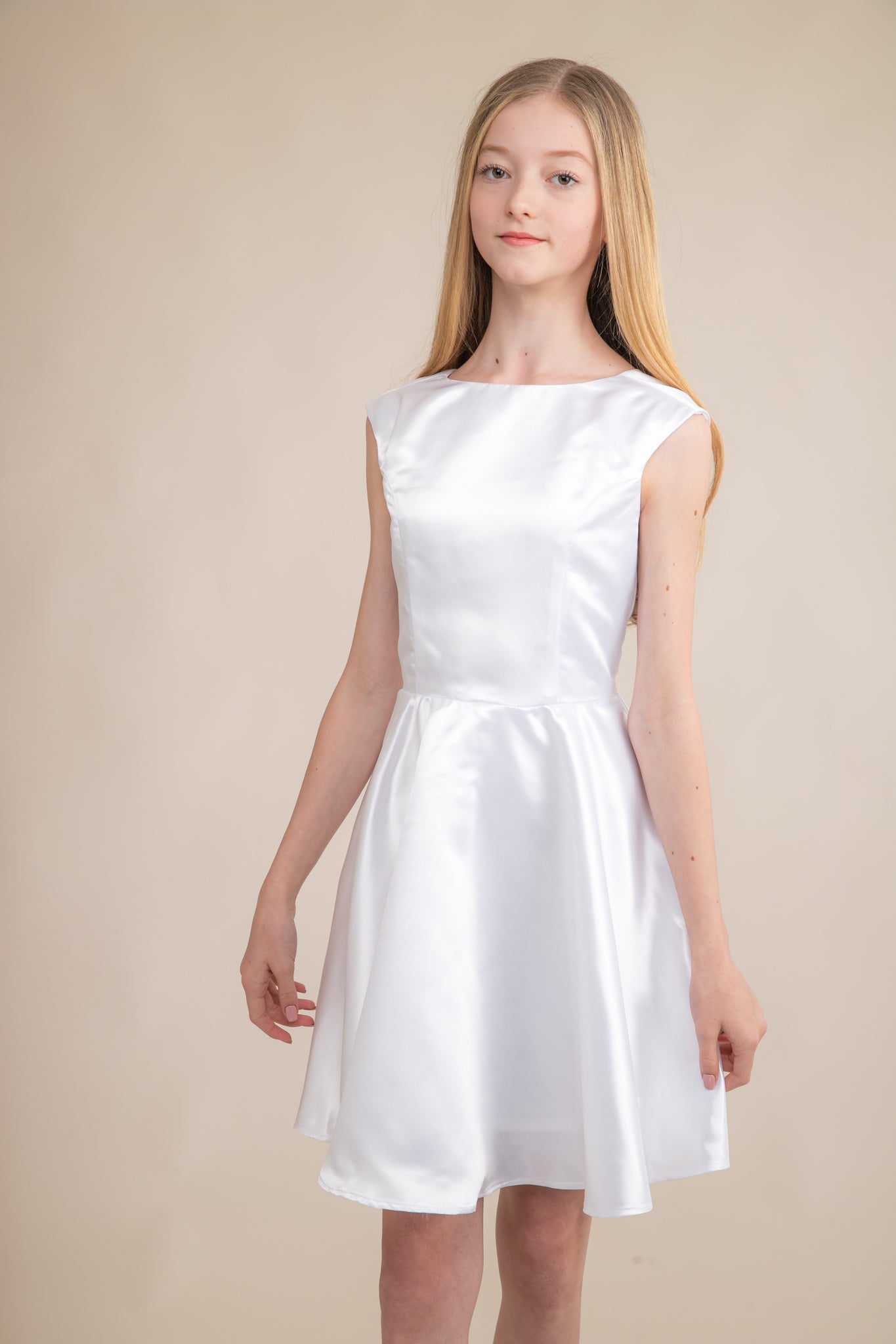 This is an all over satin, cap sleeve dress in white with non-stretch material, zipper back, and longer length detailing. This dress is perfect for any religious event like bat mitzvah, cotillion or church service.